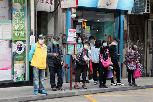 people wearing masks in front of shop